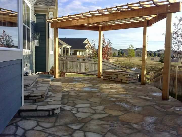 Patio featuring a pergola and stone steps, designed by a landscape company for outdoor relaxation and aesthetics.