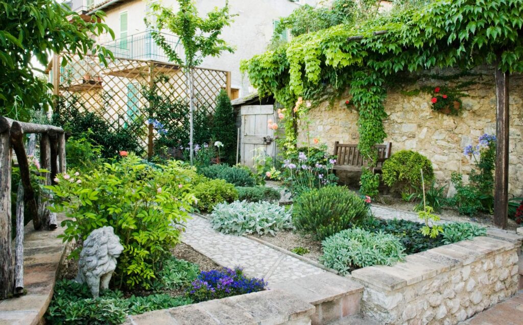 Custom landscape design in a small courtyard featuring stone pathways, lush greenery, and wooden seating.