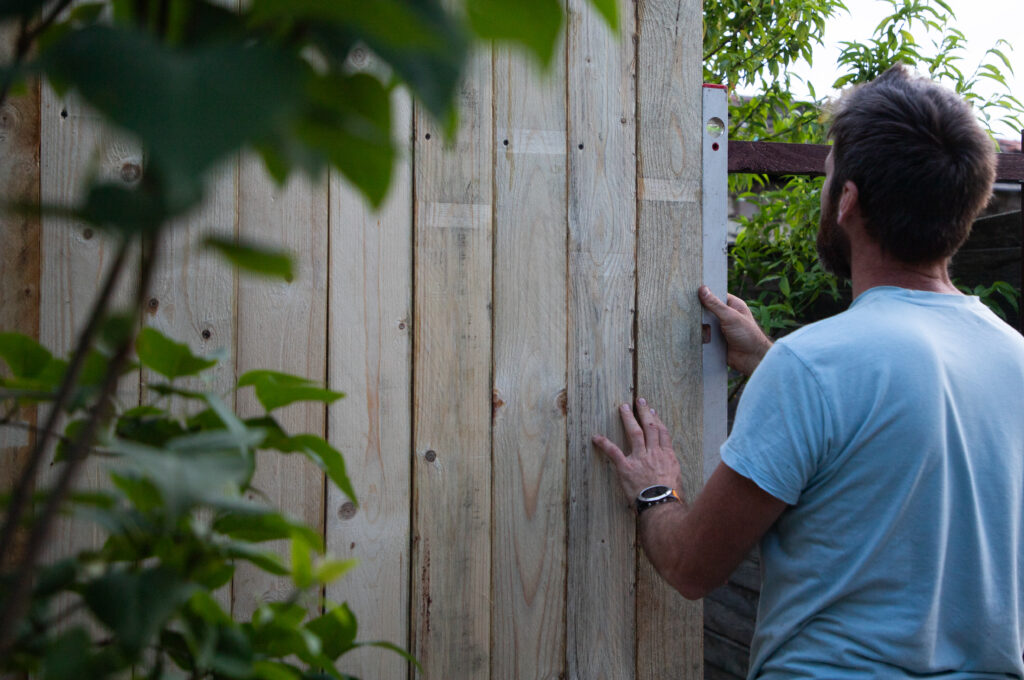 Fence installer working on a residential project with insured fencing services.